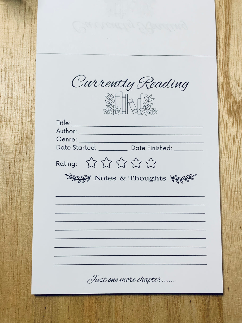 Currently Reading book tracker sheet on a wooden surface