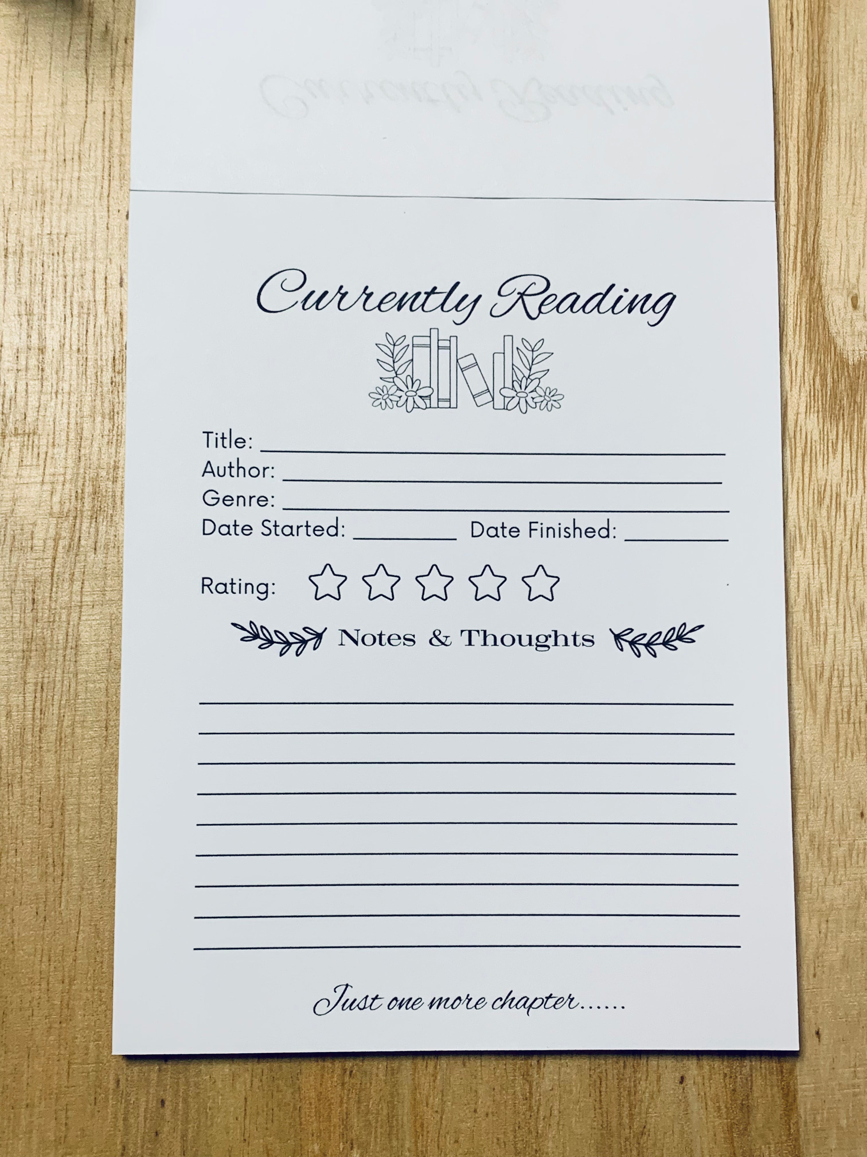 Currently Reading book tracker sheet on a wooden surface