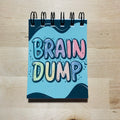 Notebook with 'Brain Dump' on a wooden surface