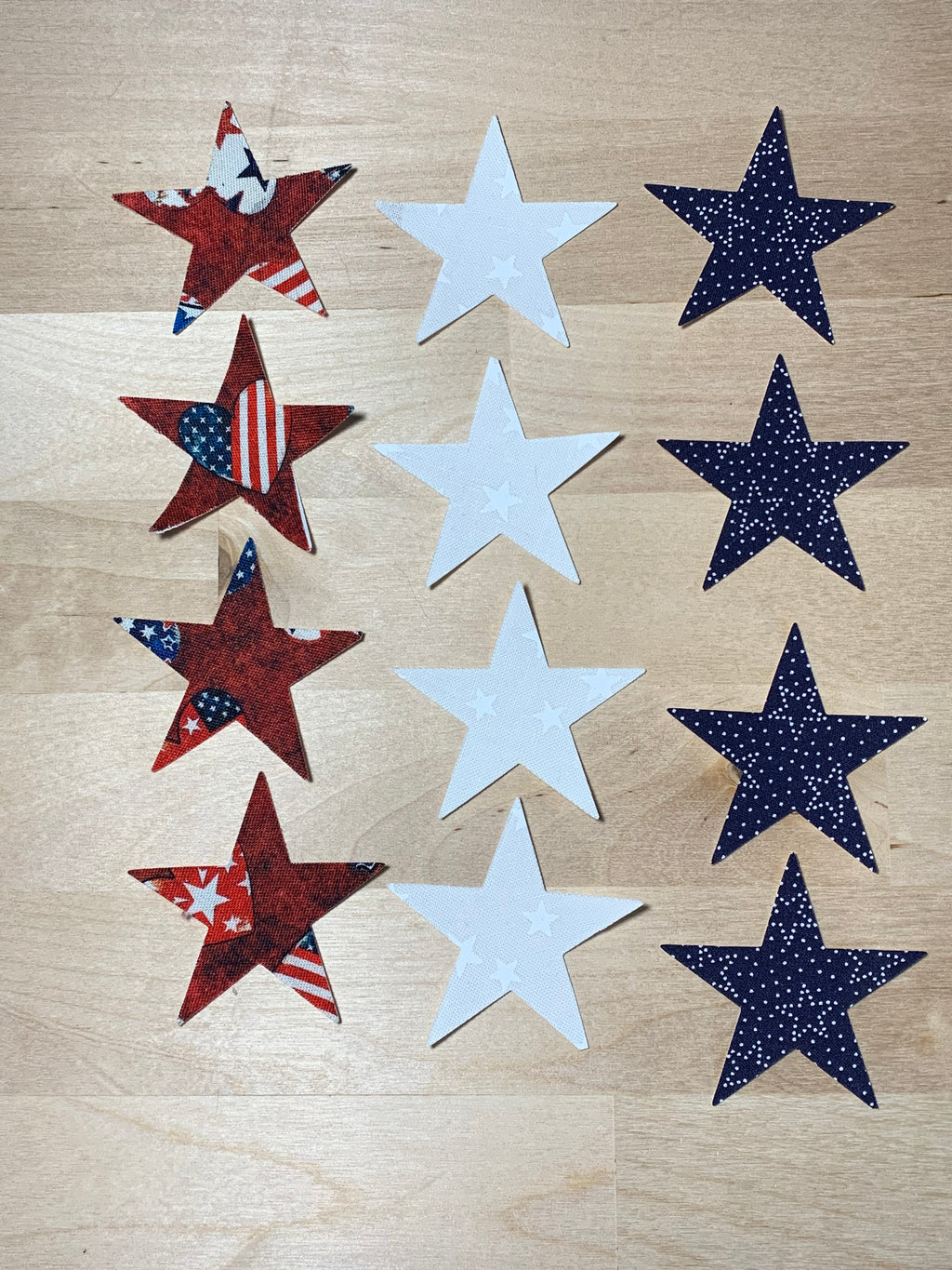 Set of star-shaped decorations in red, white, and blue on a wooden surface