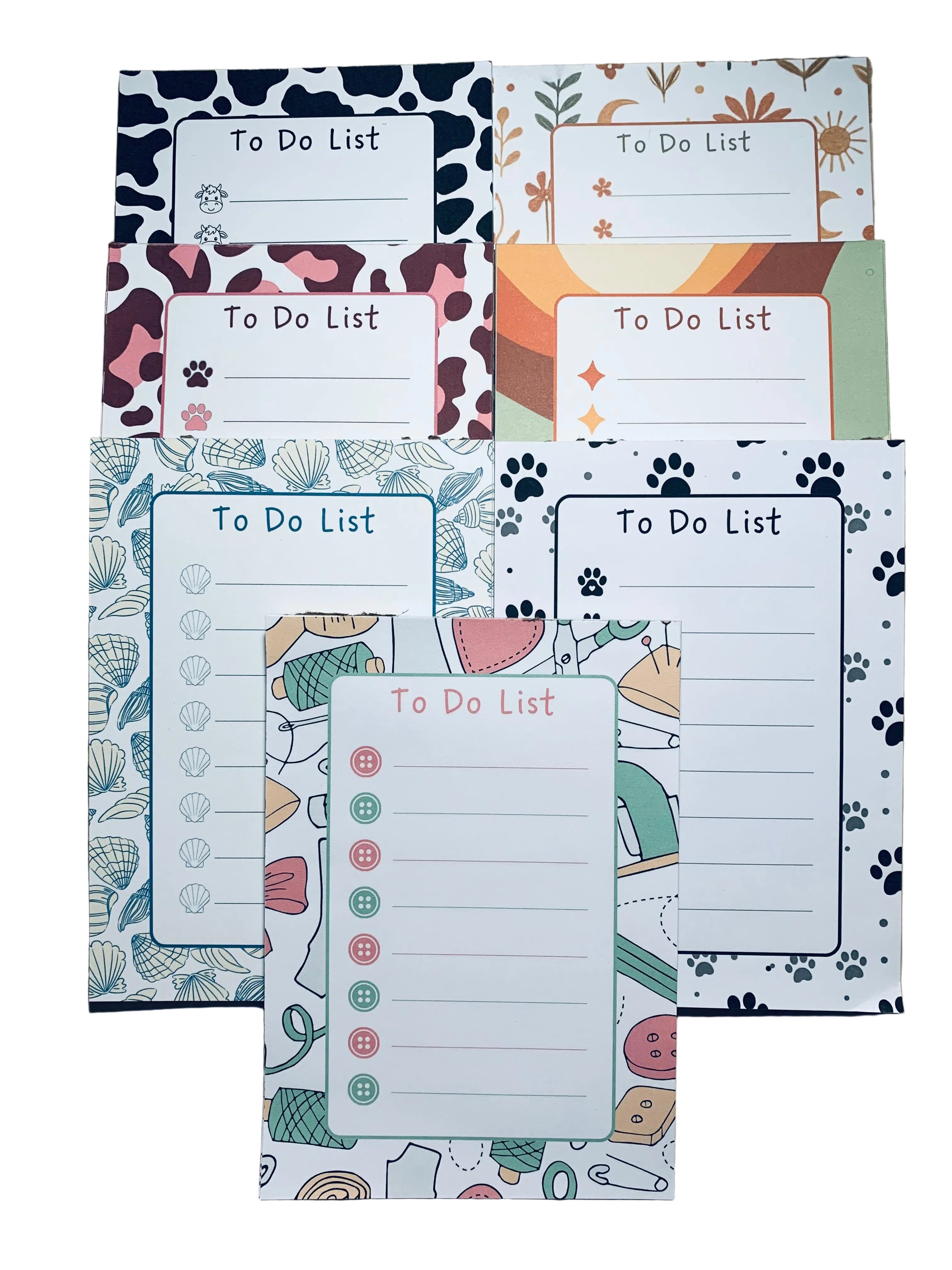 Set of colorful to-do list pads with various designs on a wooden surface.