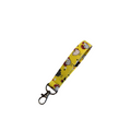 Yellow lanyard with cartoon character design on a light wooden surface with pink flowers.