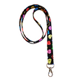 Colorful lanyard with floral design on a light wooden surface with pink flowers.
