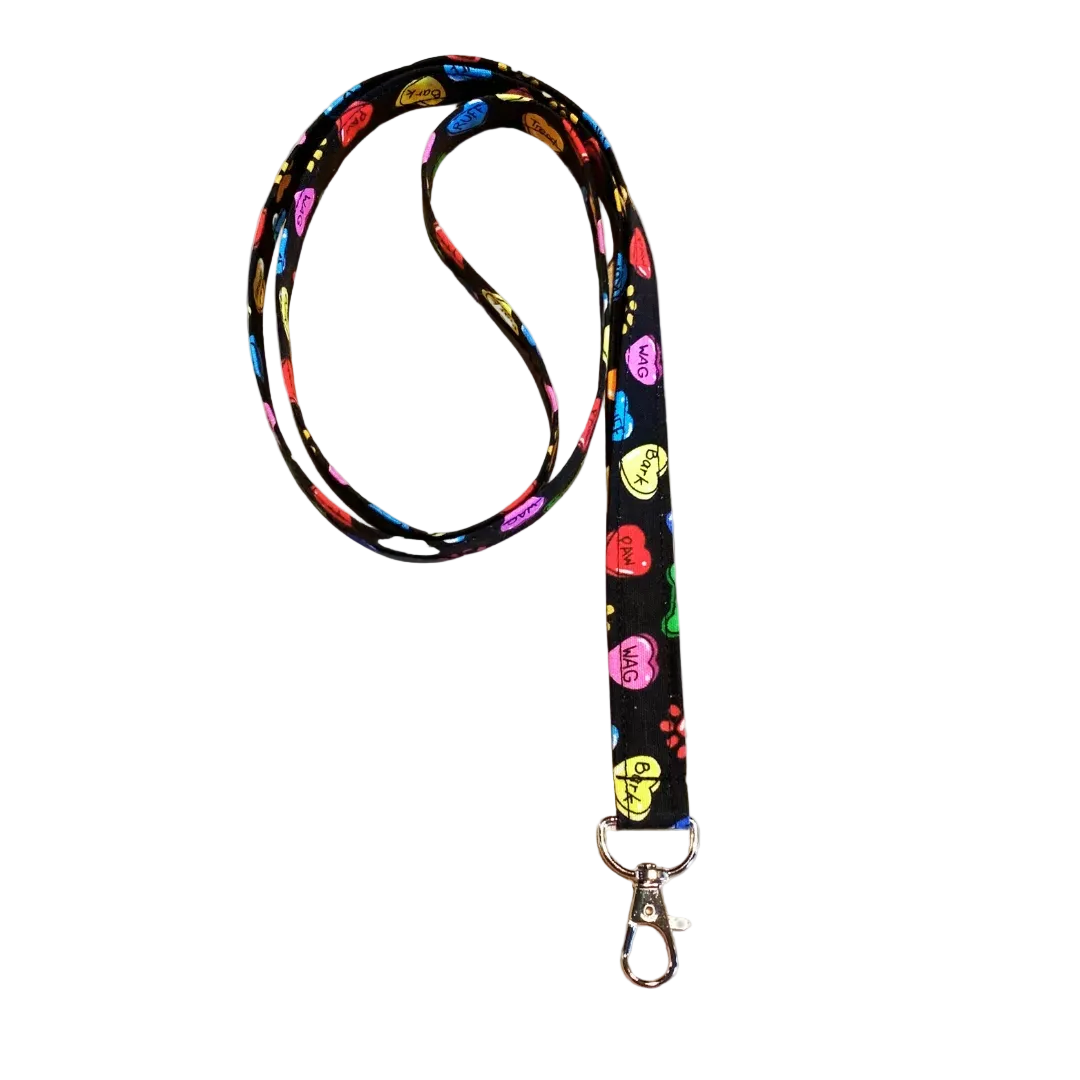 Colorful lanyard with floral design on a light wooden surface with pink flowers.